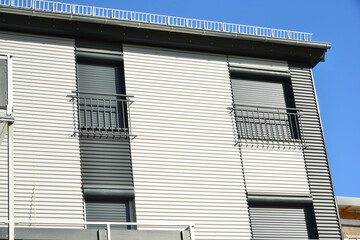 Französische Balkone an moderner Neubau-Hausfront mit Wellblechprofil-Fassadenverkleidung
