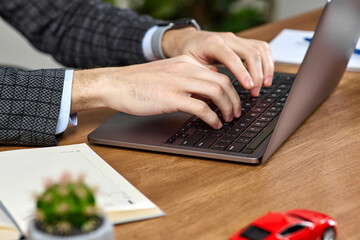 Male hands typing on a laptop keyboard