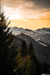 Fototapeta na wymiar Orange sunset on alpine mountains and lake