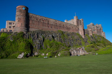 Fototapeta na wymiar Bamburgh Castle against a bright blue summer sky. Northumberland, UK