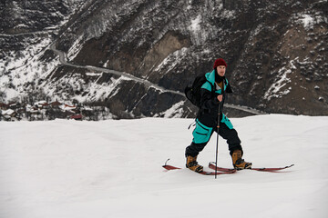 male skier walking against winter mountain landscape