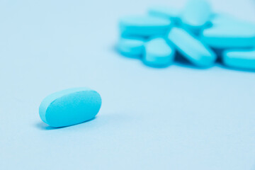 Many blue pills macro on paper background with copy space