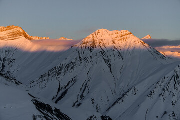 Awesome picturesque view of winter mountain hills covered with snow and shiny sun rays