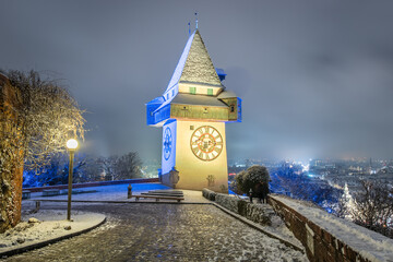 The famous landmark of Graz in Austria, the clock tower at the Schloßberg in winter illuminated with the colors of Ukraine