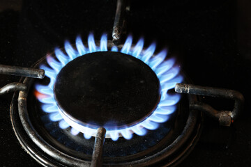 Spalanie gazu ziemnego na kuchennej kuchence gazowej. Panel ze stali z pierścieniowym palnikiem...