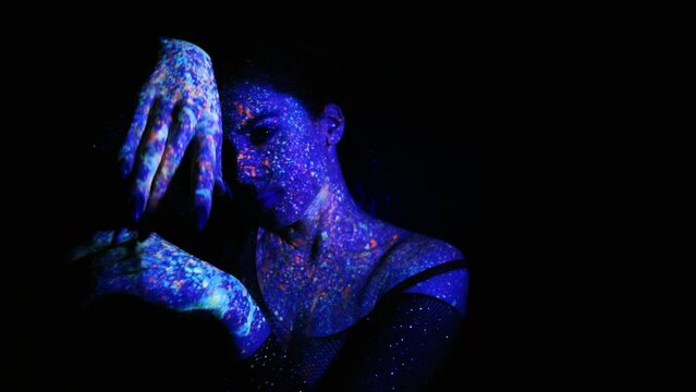 Model woman in neon light, beautiful model girl with fluorescent makeup, art design of disco dancer dancing in uv light, colorful makeup. Nightclub, Party. 4K video.