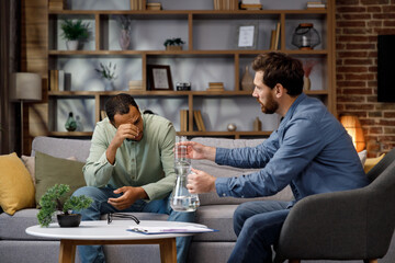 A visit to an African American psychologist. A man sits on a couch and talks to a psychotherapist. Depression, apathy, stress, burnout at work. Help of a psychologist.