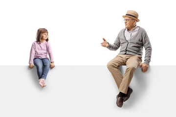 Grandfather talking to a little girl seated on a blank panel