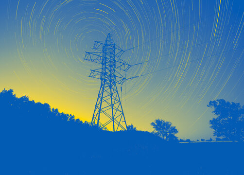 transmission tower against star trails colored in colors of Ukrainian flag