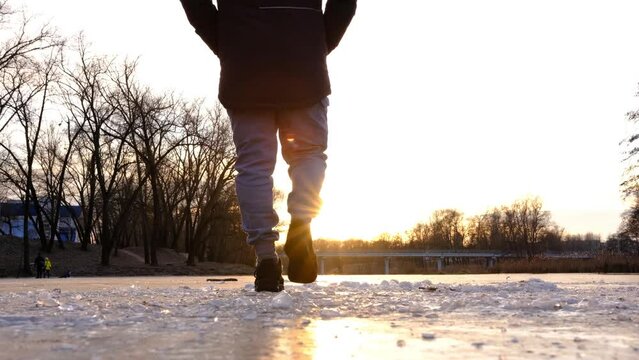 The lonely figure of a man walking on the frozen r