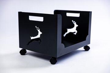 An empty metal box for firewood on white background in a studio photoshoot. A deer symbol cutout on the sides. High quality photo