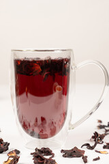 Red hibiscus tea from the petals of the Sudanese rose in a glass cup with a double bottom