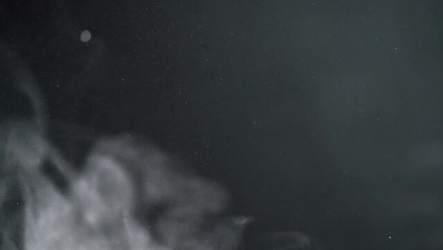 Slow motion of dust clouds on a black background