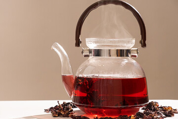 Red hibiscus tea from the petals of a Sudanese rose in a glass teapot, copy the place for the text