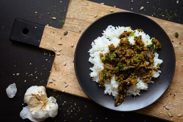 Rice with minced meat sauce on dark wood table