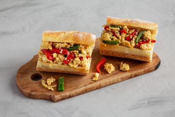 Homemade Easter Pepper and Egg Sandwich on a rustic wooden board, side view.
