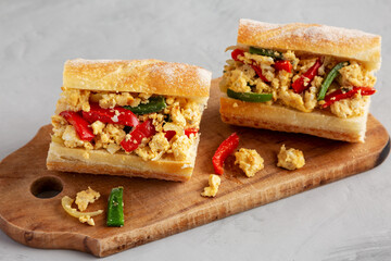 Homemade Easter Pepper and Egg Sandwich on a rustic wooden board, side view.