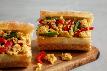 Homemade Easter Pepper and Egg Sandwich on a rustic wooden board, side view. Close-up.