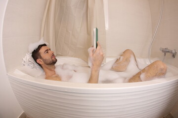 Man reading a novel in the bathtub 