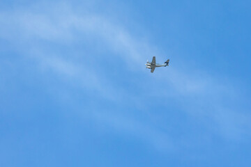 A twin-engine plane flying in a blue sky. Transport. Air travel.
