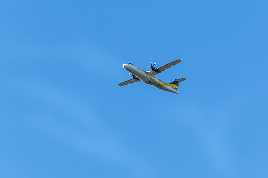 A twin-engine plane flying in a blue sky. Transport. Air travel.