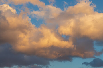 Blue sky with white clouds. The sun shines through the clouds.