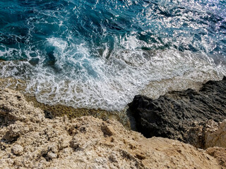 Clear blue sea against a rocky shore