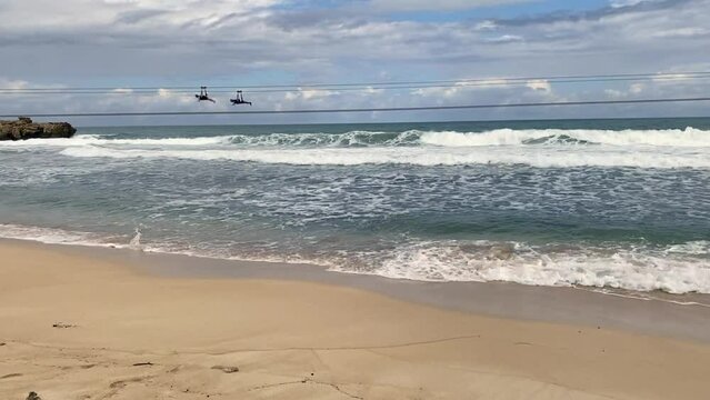 Adrenaline Beach at Labadee, Haiti. Dragon's Fire and Dragon's Breath zipline. Labadee is a private resort leased by Royal Caribbean Cruises. Superman style zip line over Caribbean beach and waves.
