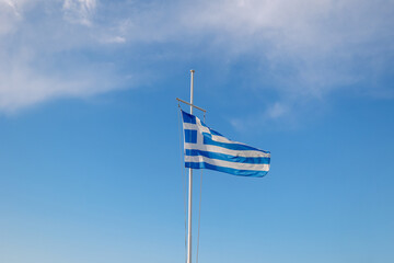 Greece flag is flying in air on blue sky background. Banner, place for text. High quality photo