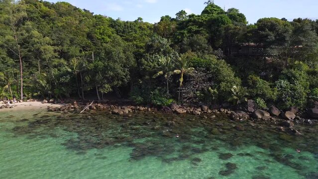 snorkeling in crystal clear water, black stone. Amazing aerial view flight drone