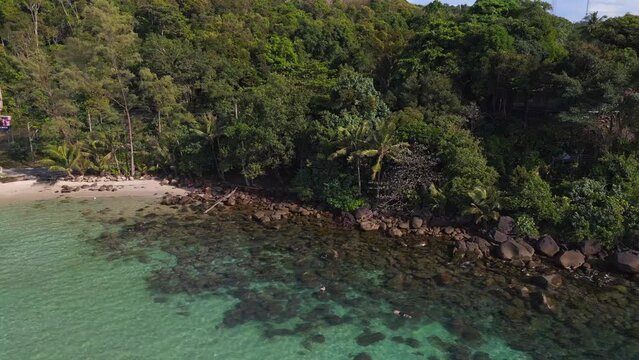 snorkeling at stones in crystal clear water. Lovely aerial view flight drone