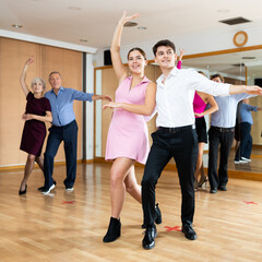 Young happy couple performing a paired dance in ballroom