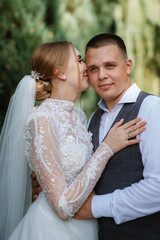 young couple the groom in a plaid suit and the bride in a chic white dress