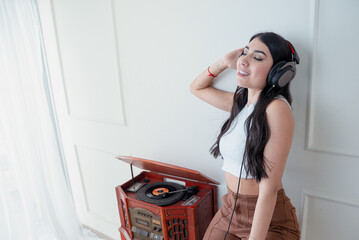 Young woman listening to music with vintage turntable in living room