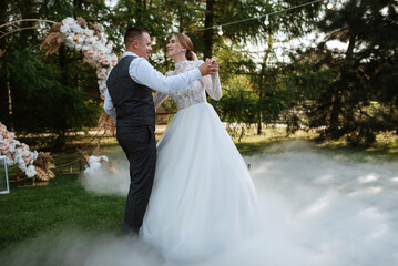 the first wedding dance of the bride and groom on a green meadow