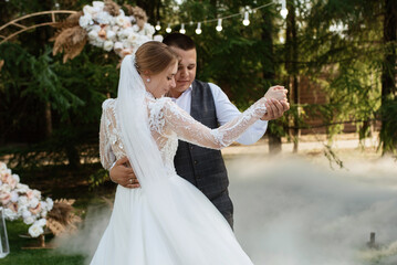 the first wedding dance of the bride and groom on a green meadow