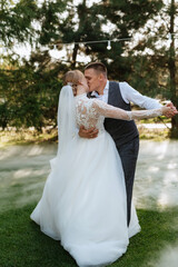 the first wedding dance of the bride and groom on a green meadow