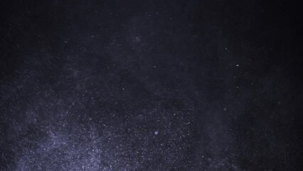 Purple dust particles behave like a snowstorm and fly chaotically through the air