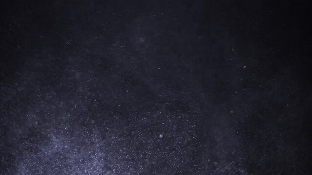 Purple dust particles behave like a snowstorm and fly chaotically through the air