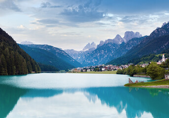 Tranquil summer Italian dolomites mountain lake and village view (Auronzo di Cadore).