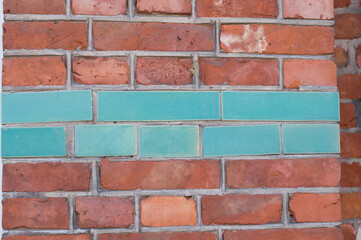 Obraz premium natural red brick background, masonry texture with blue ceramic tiles insert