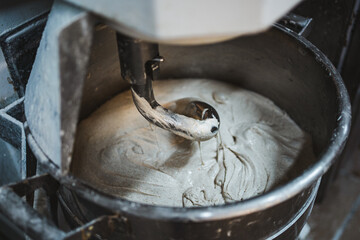 Electric dough mixer machine at the kitchen of bakery. It is mixing sourdough.