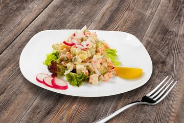 plate of fresh tasty salad on wooden table