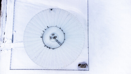 Drone overhead view of a water tower with communications antennae mounted on top 