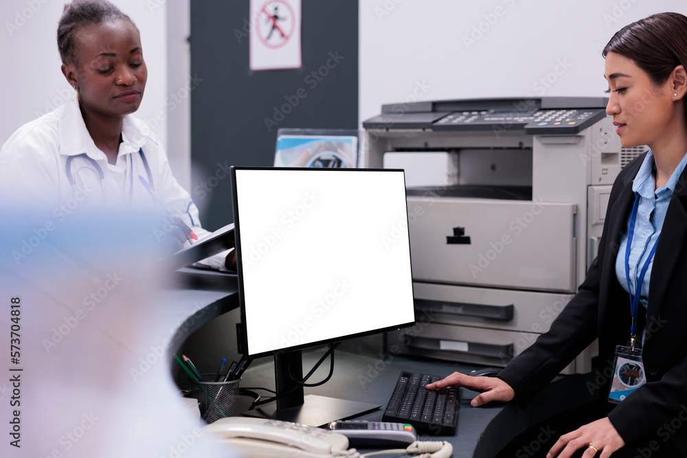 Poster asian reception worker using white screen on computer while working at hospital registration counter
