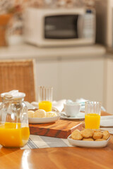 Cheese breads on the table with orange juice on breakfast. (Pao de queijo)