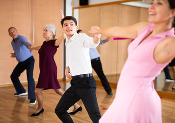 Obraz premium Spirited young pair training Latino dance during workout session. Pairs training ballroom dance in hall
