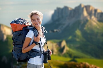 Walking woman with backpack in mountains in summer.