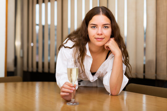 Portrait of businesswoman with a glass of wine at the table in the office