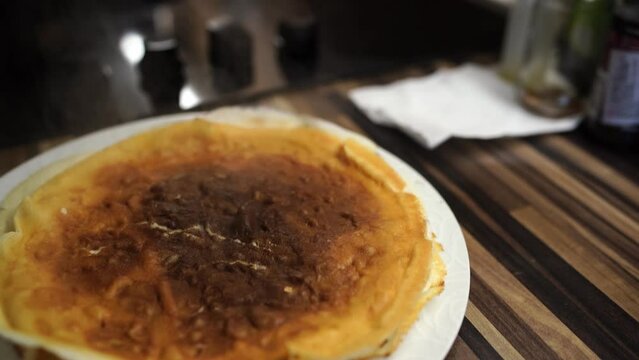 Ruddy pancakes steam on a plate on the table